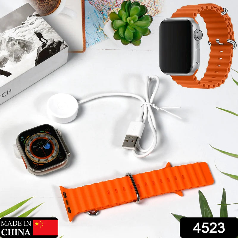 Smartwatch with orange band and accessories on a white surface with plants.