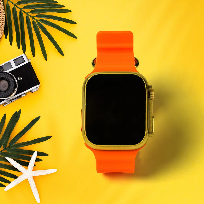 Smartwatch with orange band on a yellow background with palm leaves and a camera.