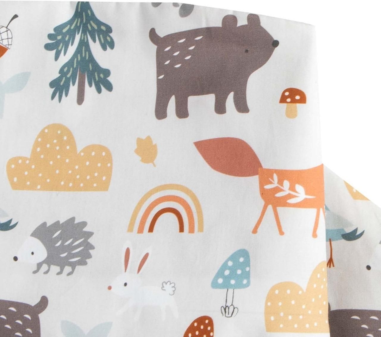 Fabric with forest-themed pattern including animals, trees, and rainbow on a white background