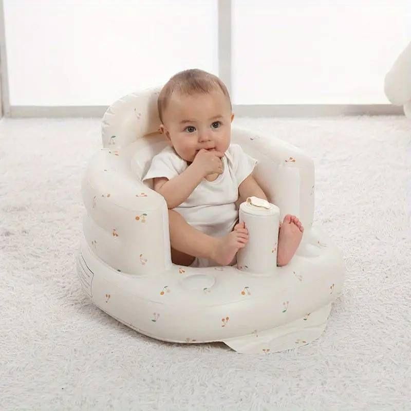 Baby sitting in a white inflatable seat on a light gray floor.
